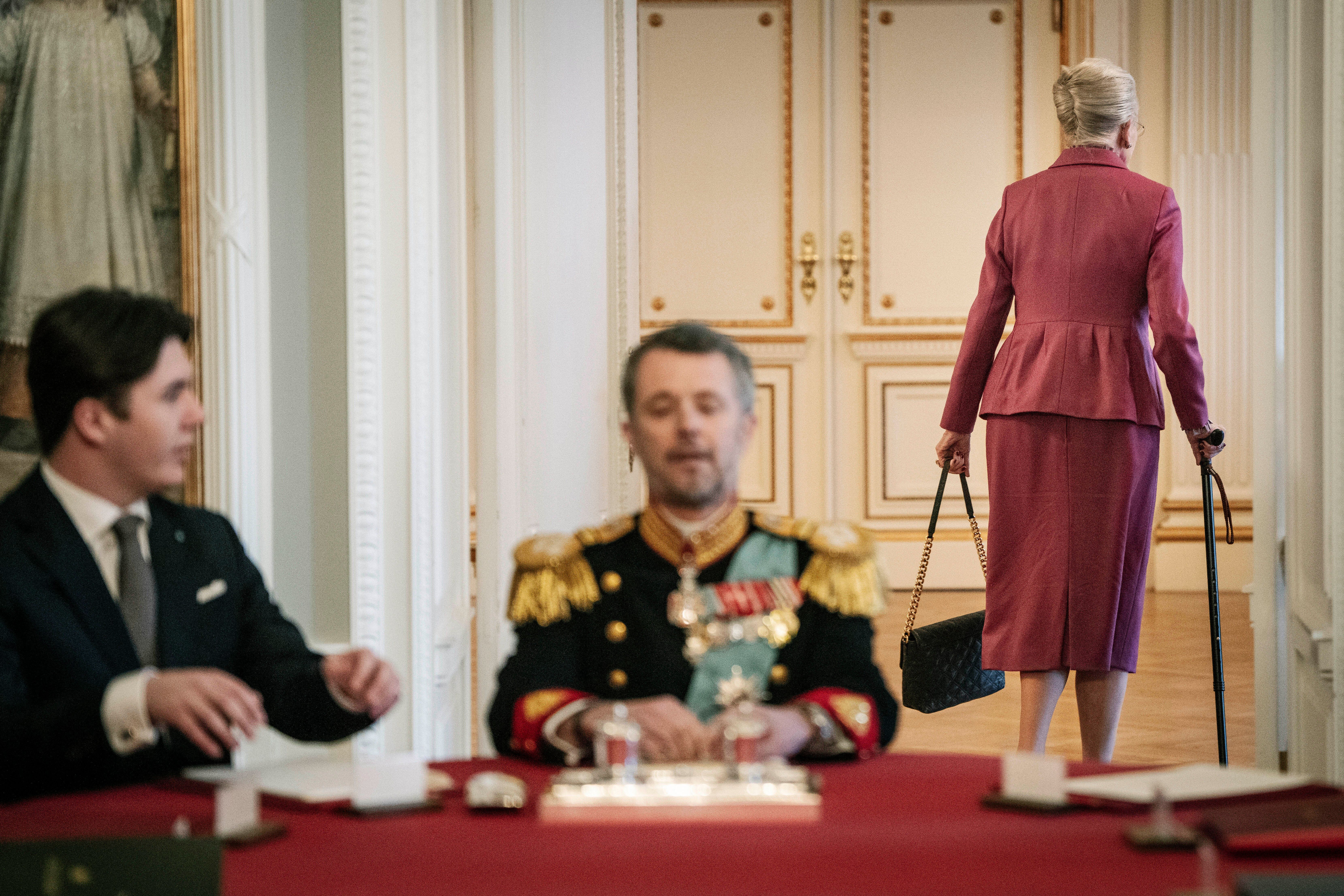 丹麥女王起身離開內閣會議，象徵退位。（AP）