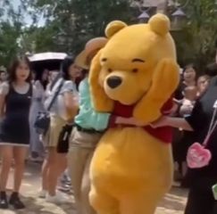 小熊維尼人偶被攻擊後抱著頭離開。（翻攝自微博）