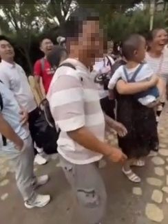 小熊維尼人偶被攻擊後抱著頭離開。（翻攝自微博）