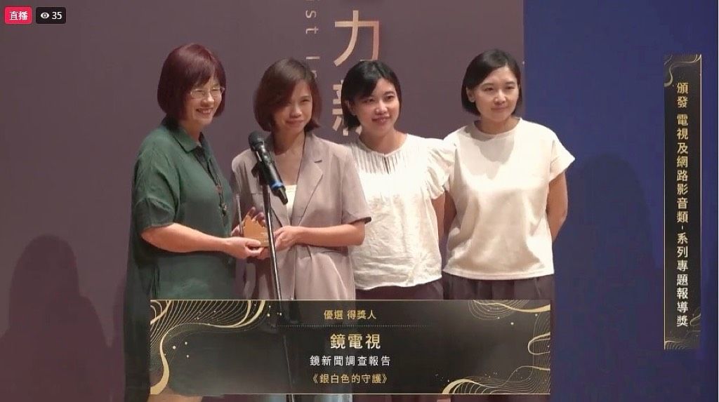 《鏡新聞調查報告》團隊(左起)簡如屏、戴佳儀、許珮珍，從頒獎人陳秀鳳老師手中接下優選大獎獎座。