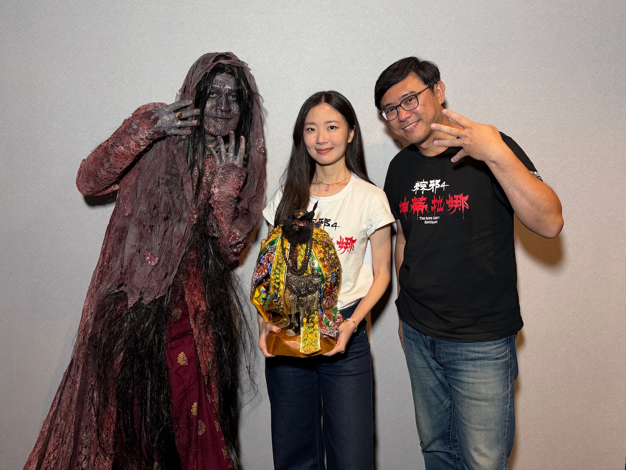 《粽邪4:坤蒂拉娜》導演廖士涵(右起)與抱著鍾馗老爺金身的演員許安植、女鬼坤蒂拉娜進戲院宣傳。(華影提供)