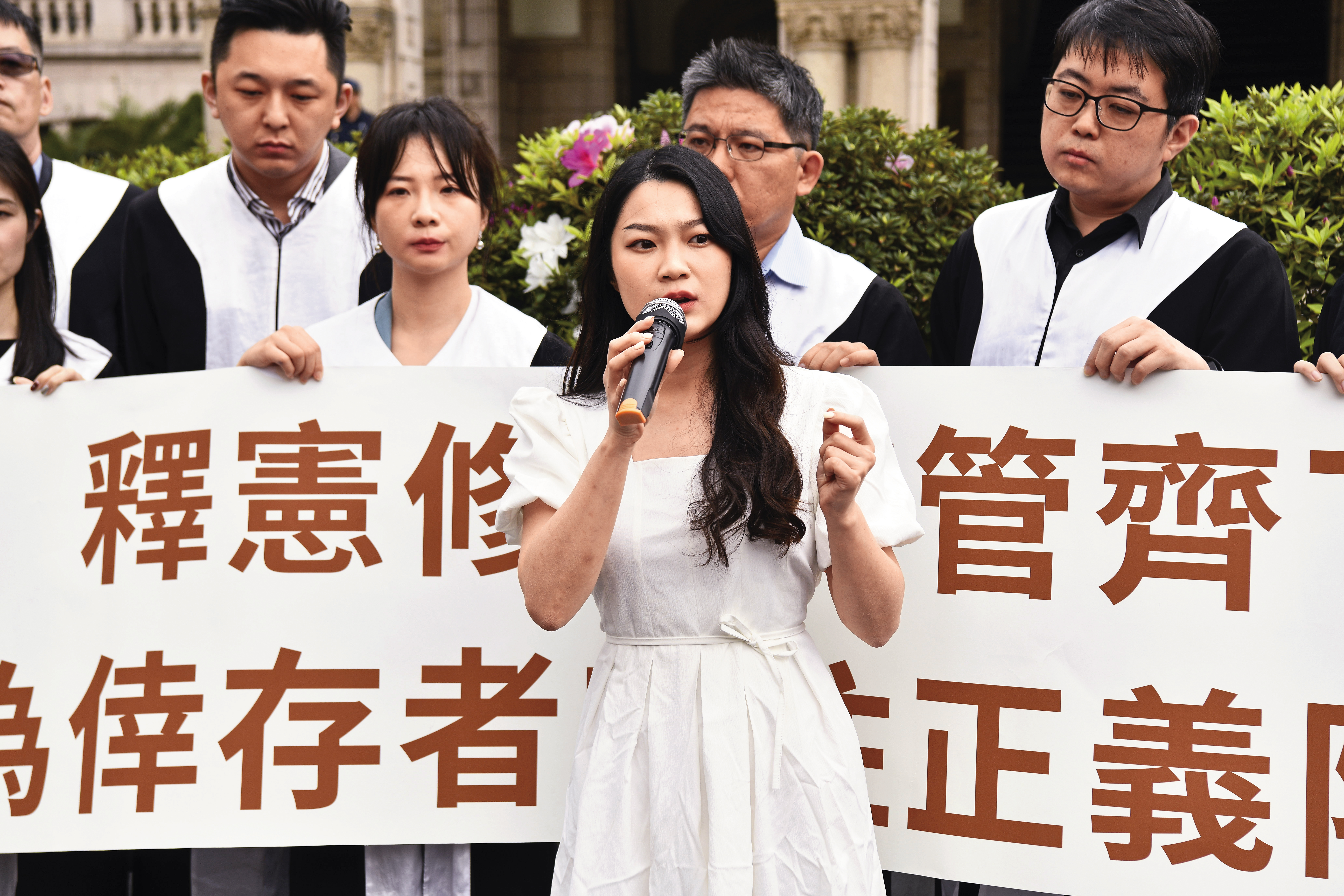 性暴力倖存者阿美(前)陪同釋憲聲請人出席憲法法庭,並在會後記者會上說明性創傷的嚴重性。(鏡報李智為)