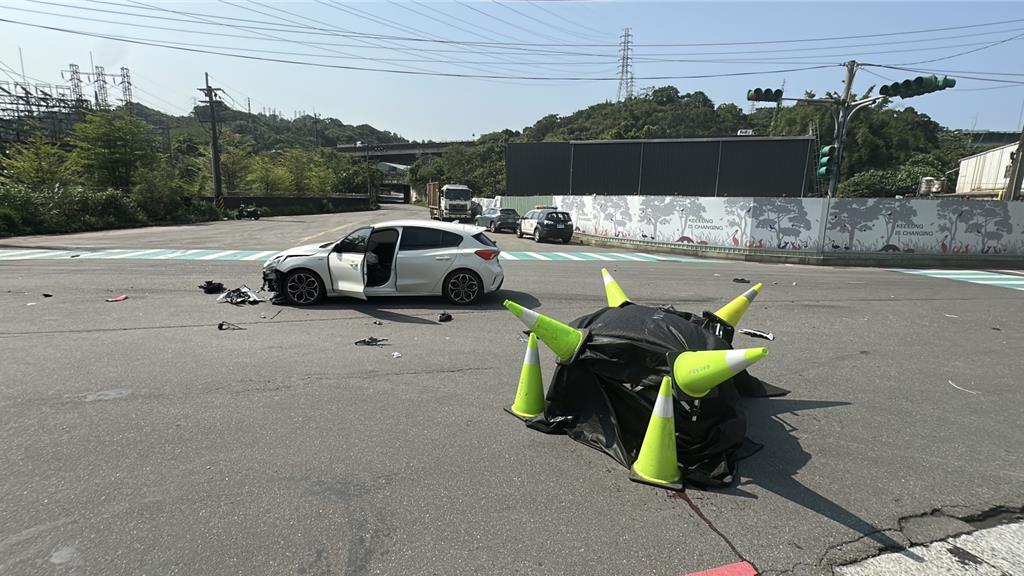 基隆七堵區今天發生汽車和機車碰撞事故,造成機車騎士慘死,警方將死者遺體用黑布覆蓋。(翻攝畫面)
