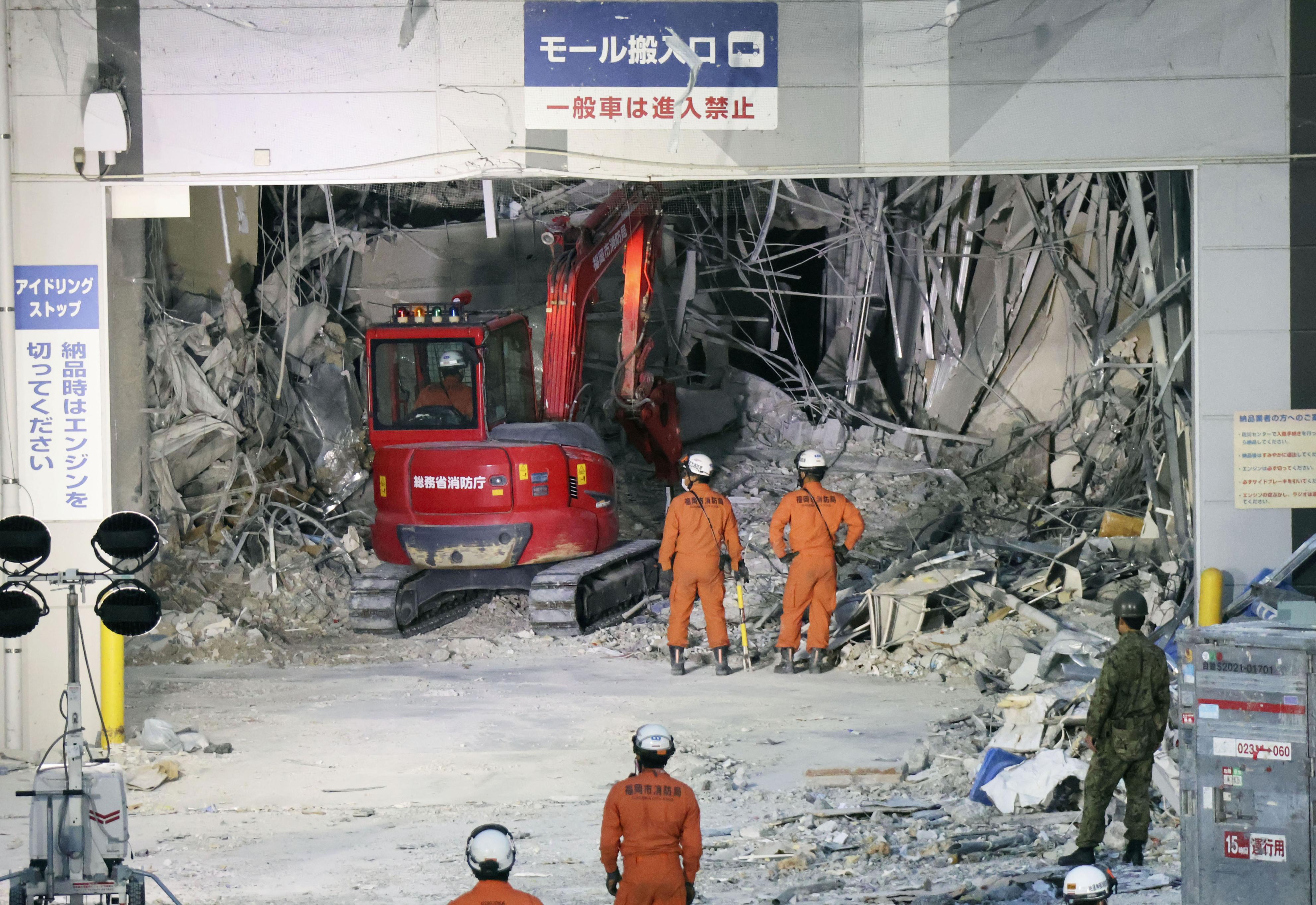 重型機械正在清理地震爆炸後受損的永旺購物中心。(AP)