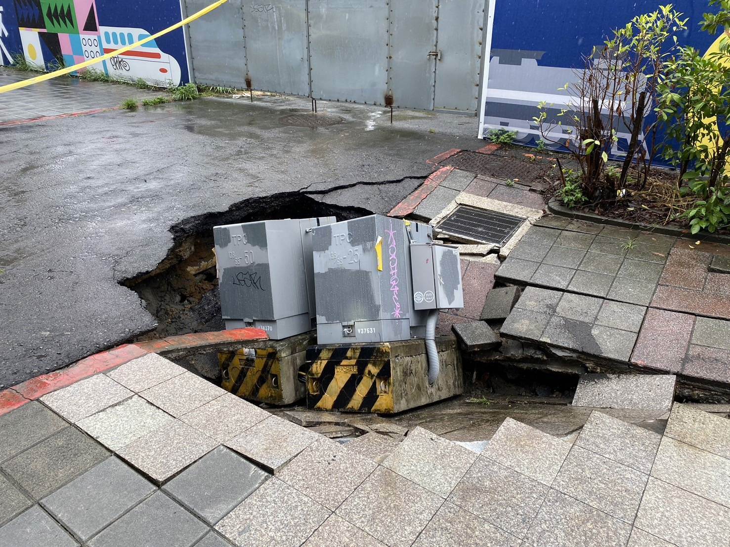 台北市捷運北門站外人行道突然下陷,變電箱好似被吞入。(翻攝畫面)