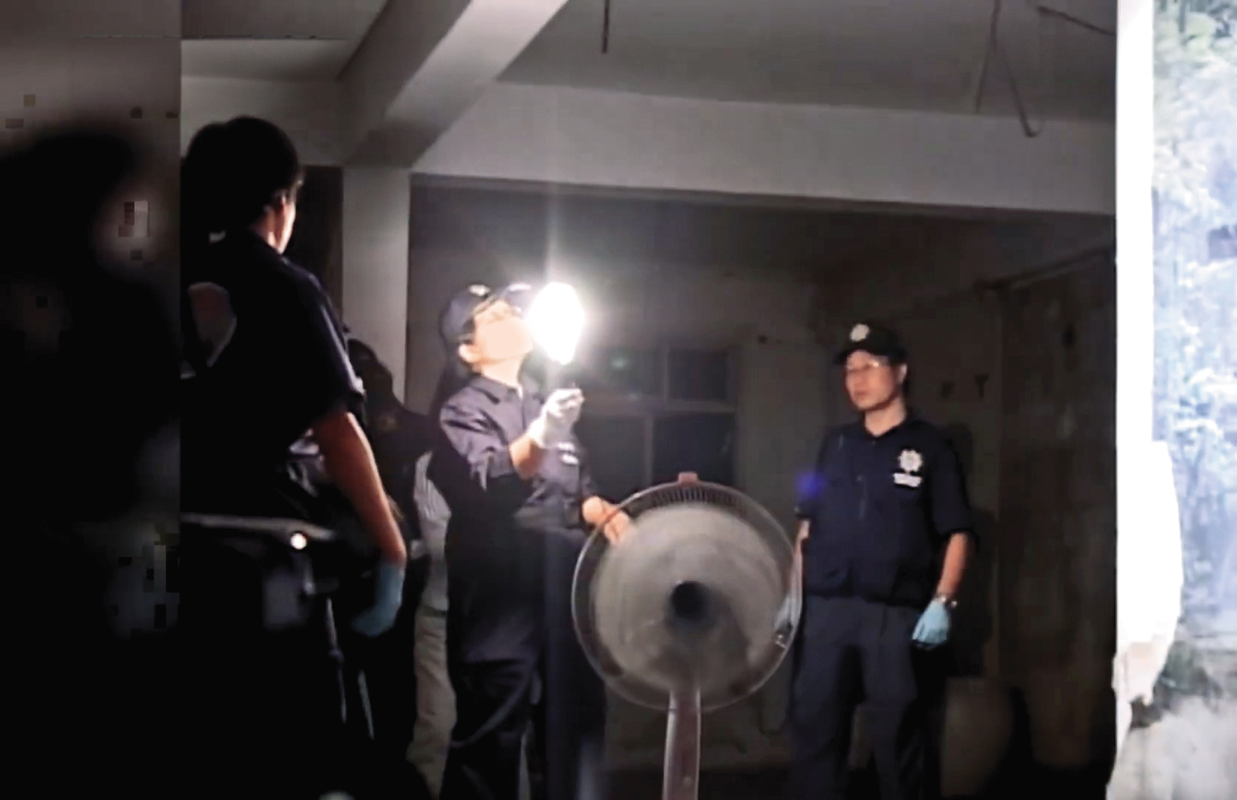 邱家老宅內部因斷電十分昏暗,警方拿手電筒邊照邊搜索。(翻攝東森新聞)