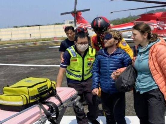 一對外籍登山客今日在八通關越嶺古道摔傷右眼,經空勤總隊救援下山後,現已在醫院接受治療。(翻攝畫面)