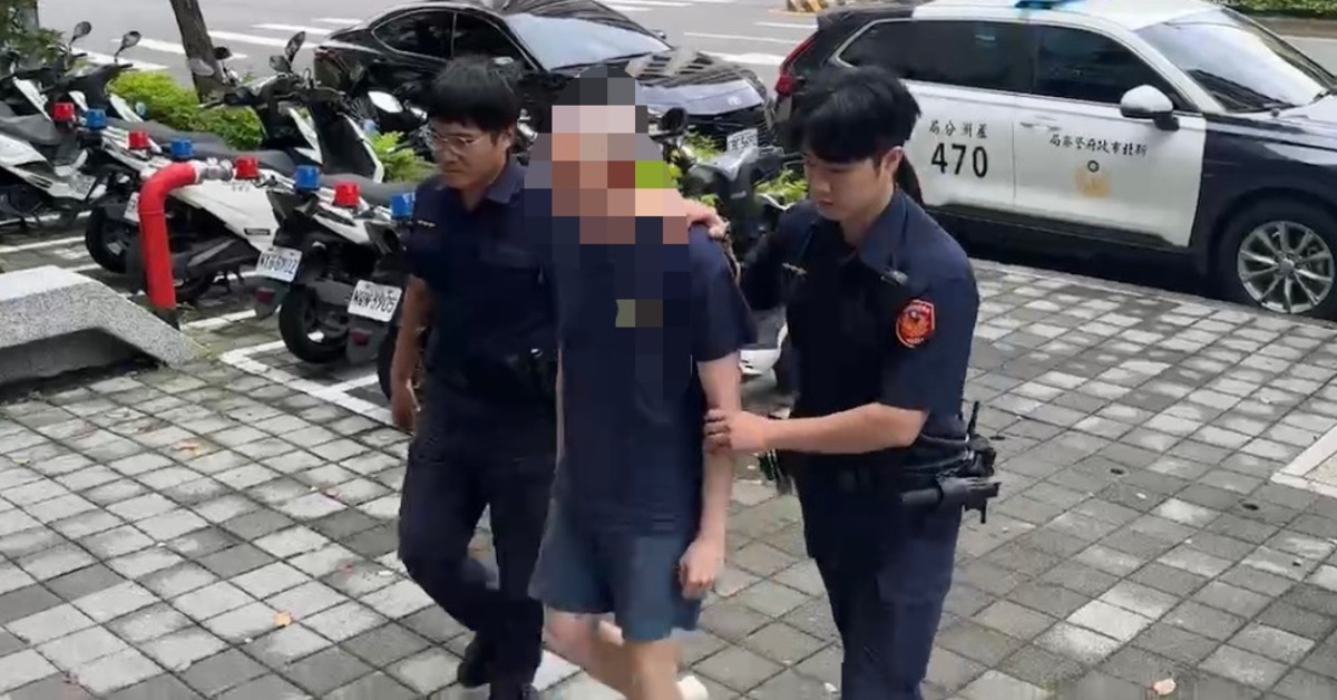 新北市五股區成泰路三段一名光頭黑衣男子在人行道上持槍徘徊,甚至做出拉滑套上膛動作並隨意咆哮,嚇壞早起上班上課的民眾。(翻攝畫面)