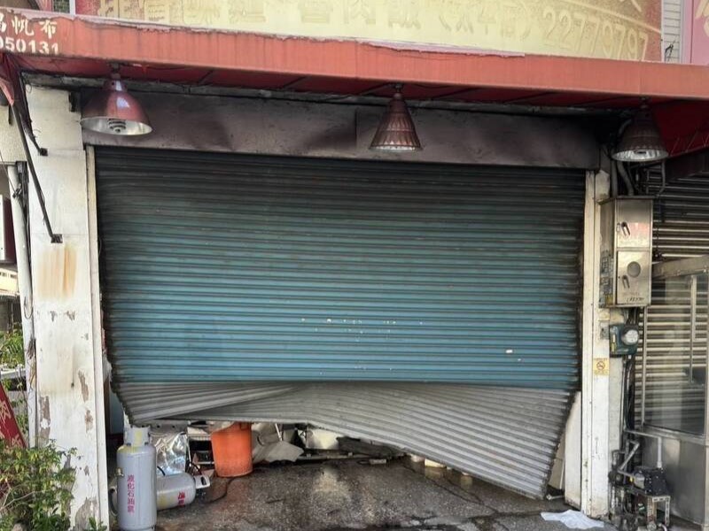 黃姓男子開車低頭撿手機,車輛失控衝撞魚翅肉羹店,鐵捲門嚴重變形。(翻攝畫面)