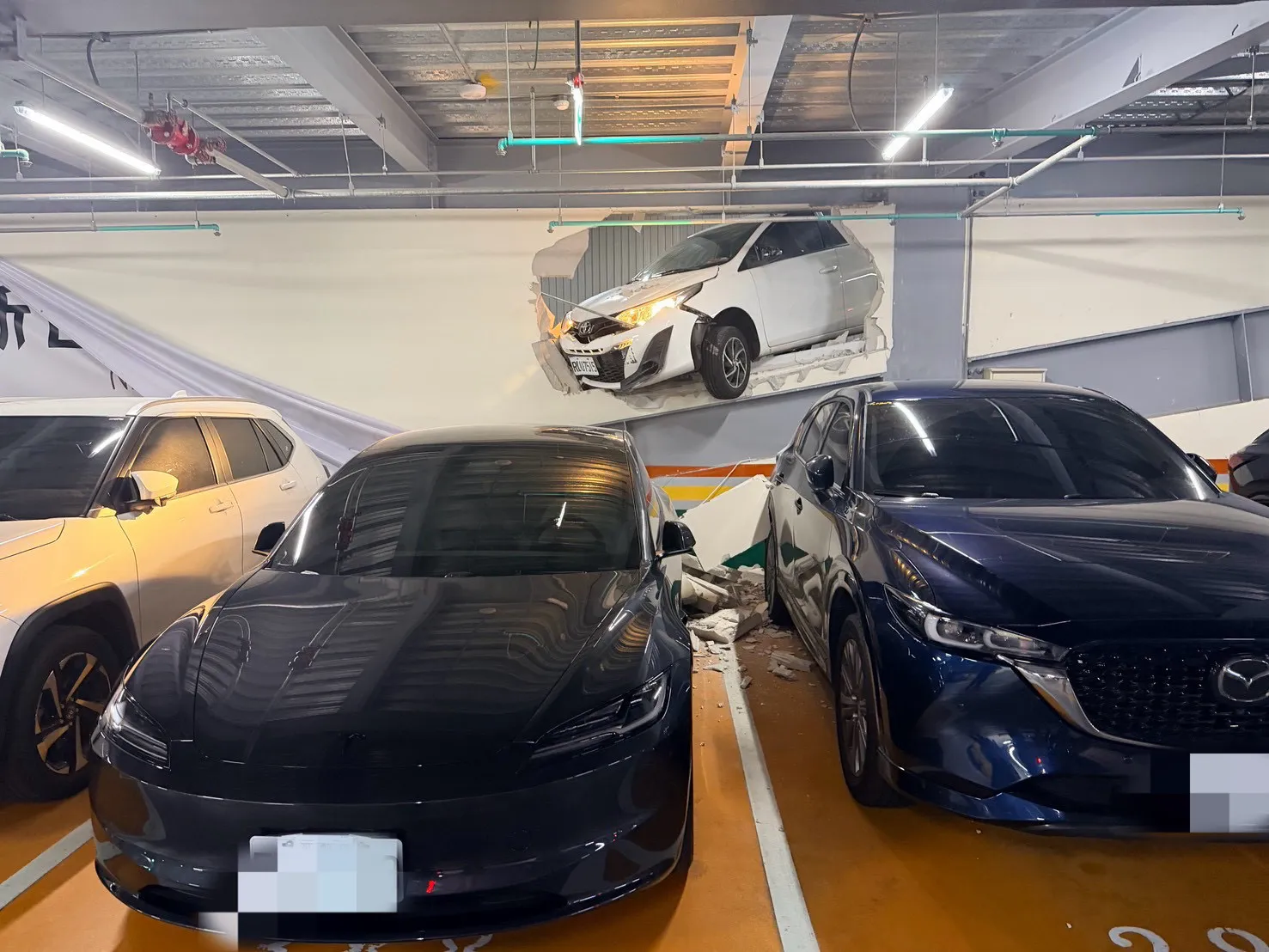 新裝置藝術？中壢商場車道白車突「穿牆」掛半空　碎屑石塊波及３車受損
