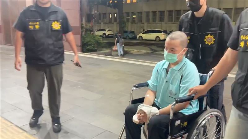 涉嫌動手行凶的黃男經醫院治療出院後,昨坐著輪椅遭警方移送北檢。(翻攝畫面)