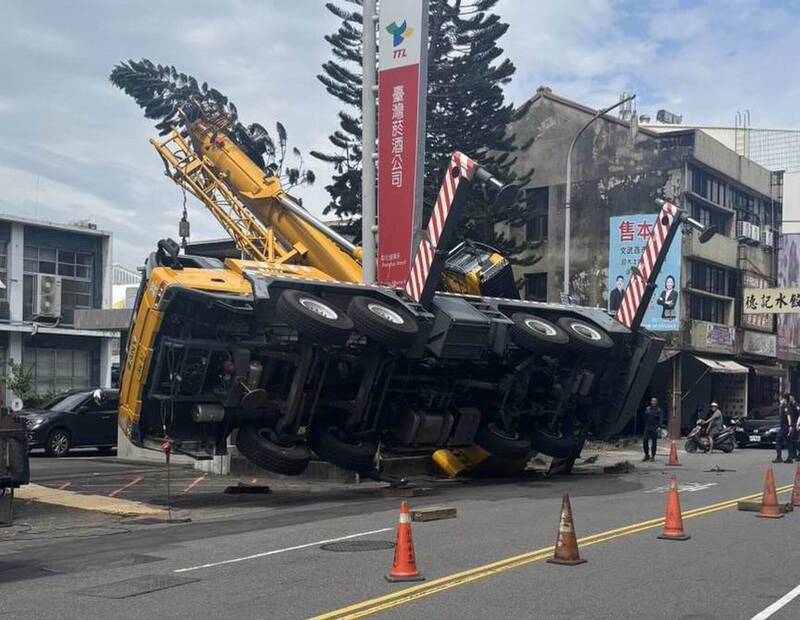 彰化市三民路昨日一輛上百噸的大型吊車陷入地面翻覆,歷時10小時才扶正解除危機。(翻攝畫面)