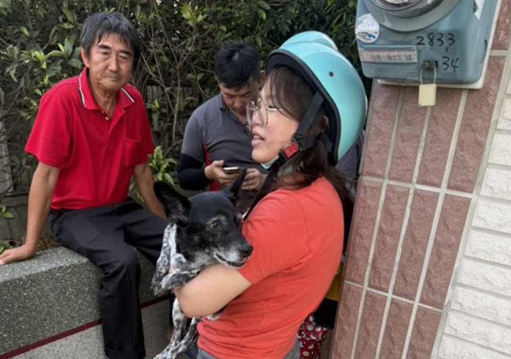 陳小姐抱起失而復得的陳美琪感動落淚,一旁為尋獲狗狗的廖姓阿北。(翻攝畫面)