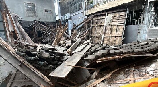一棟閒置近30年的日式木造老屋,在短短3秒內瞬間崩解化為平地,大量殘骸不僅壓毀停放的機車,更直接阻斷對面住戶的出入通道,所幸未釀成人員傷亡。(翻攝畫面)