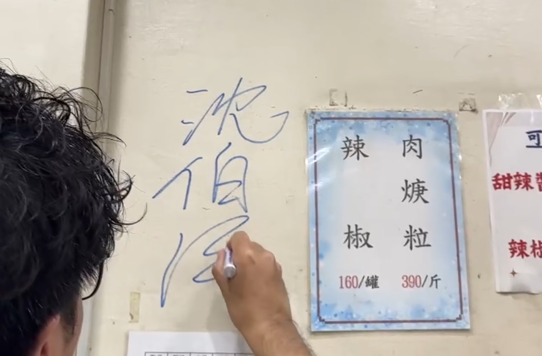 沈伯洋在饒河夜市百年老店「東發號」牆上簽名。(沈伯洋競辦提供)