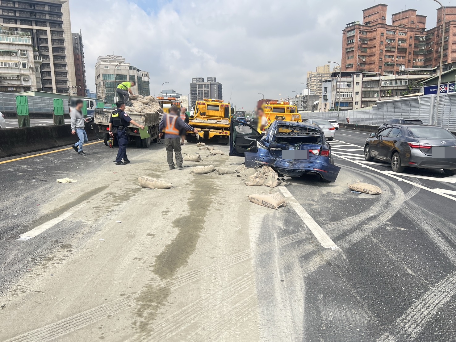 肇事的大貨車載運大量水泥包,事故現場散落大量水泥土,一度造成回堵。(翻攝畫面)