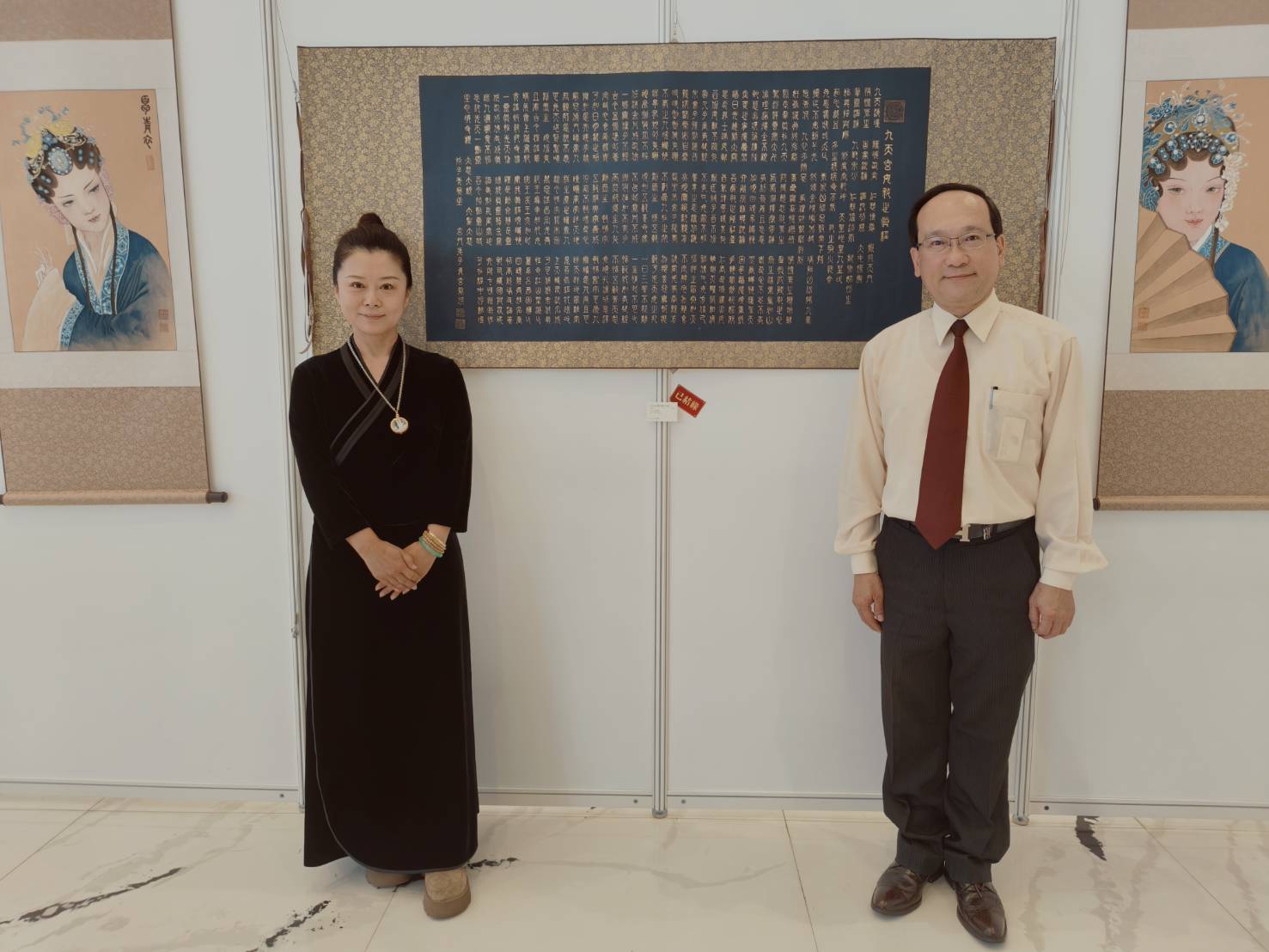 書畫家宋文琪(左)歷時多年繪製的九幅九天玄女顯身法相作品,首度自哈爾濱完整運抵台灣展出。民俗專家楊登嵙(右)表示,九天玄女在民間傳說中常以「女戰神」形象稱之,但若從現代文化角度來看,其象徵智慧、判斷、勇氣與守護。(李育材攝)