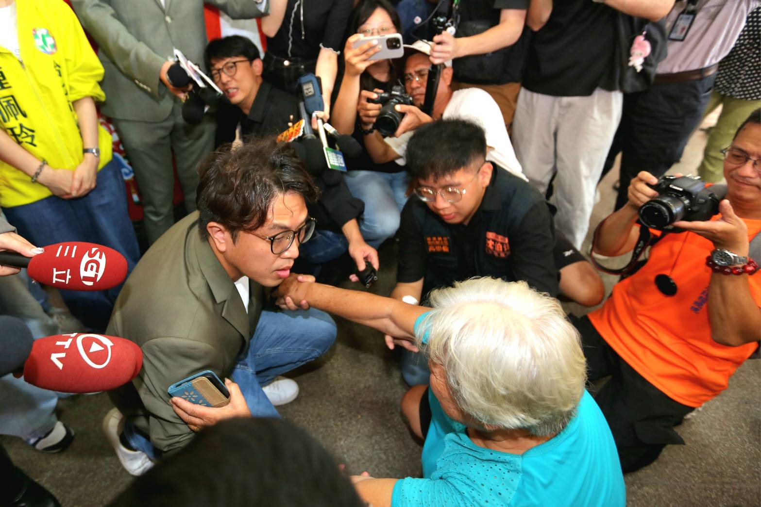 沈伯洋在社子島遇到自救會阿嬤下跪陳情,卻遭藍營酸是臨時演員。(鏡報姜永年)
