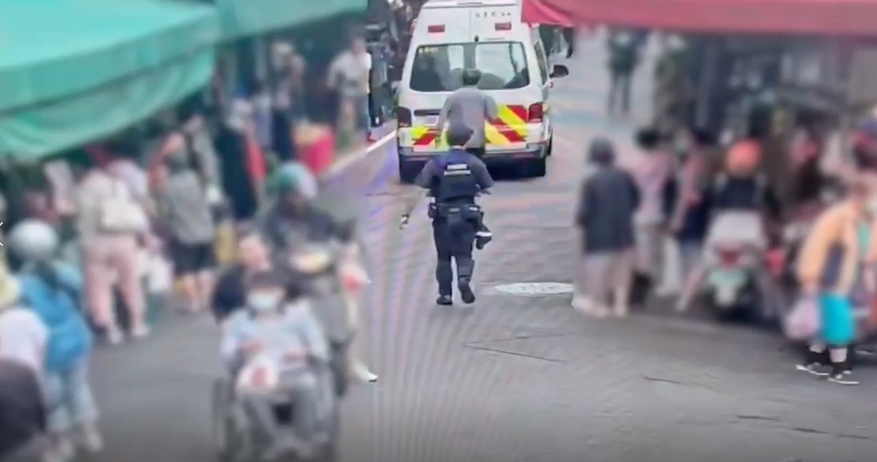 男子市場拿刀狂揮、咆哮自傷,員警迅速到場控制並戒護送醫。(警方提供)
